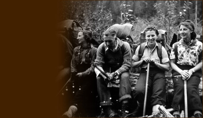 Climbers with packs rest on log. Photo NVMA 1110-7.