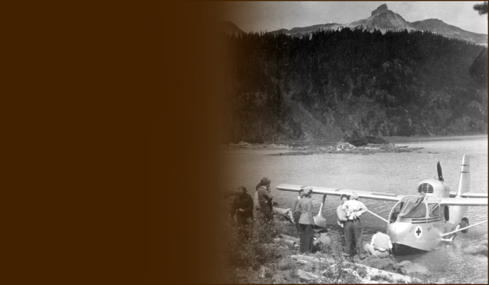 Climbers greet floatplane and pilot at lakeshore. Photo BCMC Archives 39-91.