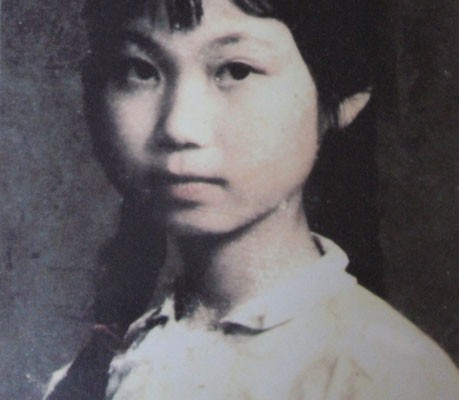 Portrait of a young girl, with a button in honour of Mao Zedong pinned to her chest.