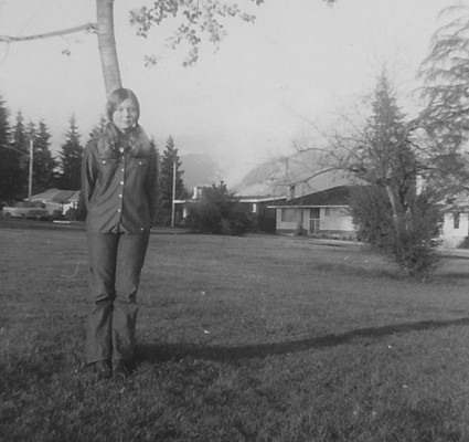 Teenage girl posing next to a young tree on Grand Boulevard.