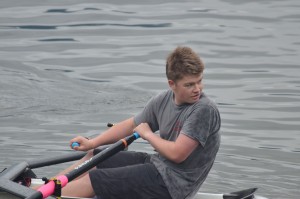Teenager practicing his rowing skills on the water.