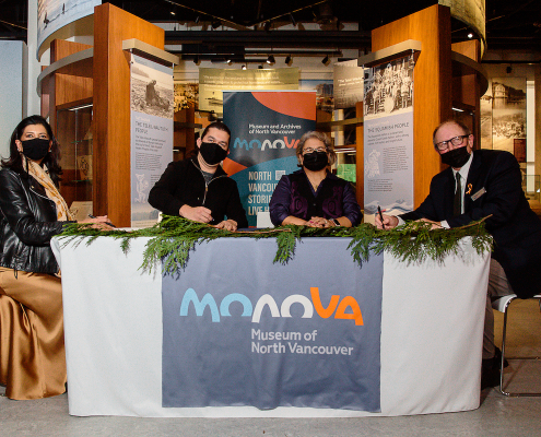 NVMA Commission Chair Dee Dhaliwal, Sḵwx̱wú7mesh Nation Chairperson Khelsilem Tl’aḵwasik̓an, Tsleil-Waututh Nation Edler Carleen Thomas, and Museum Director Wesley A. Wenhardt sign the historic agreements at the new Museum of North Vancouver, 3 December 2021. Photo: Alison Boulier