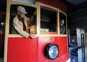 Dave Walmsley and Blaine Thompson lean out the windows of Streetcar 153 during the restoration process, April 2019. Photo: Mike Wakefield, North Shore News