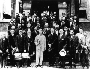 In July 1923, 16 tribes united as the Squamish Band. The group photo commemorates the government's recognition that the Squamish Band was made up of numerous village sites. The delegates (all identified) were signing Chiefs and delegates. NVMA 4835